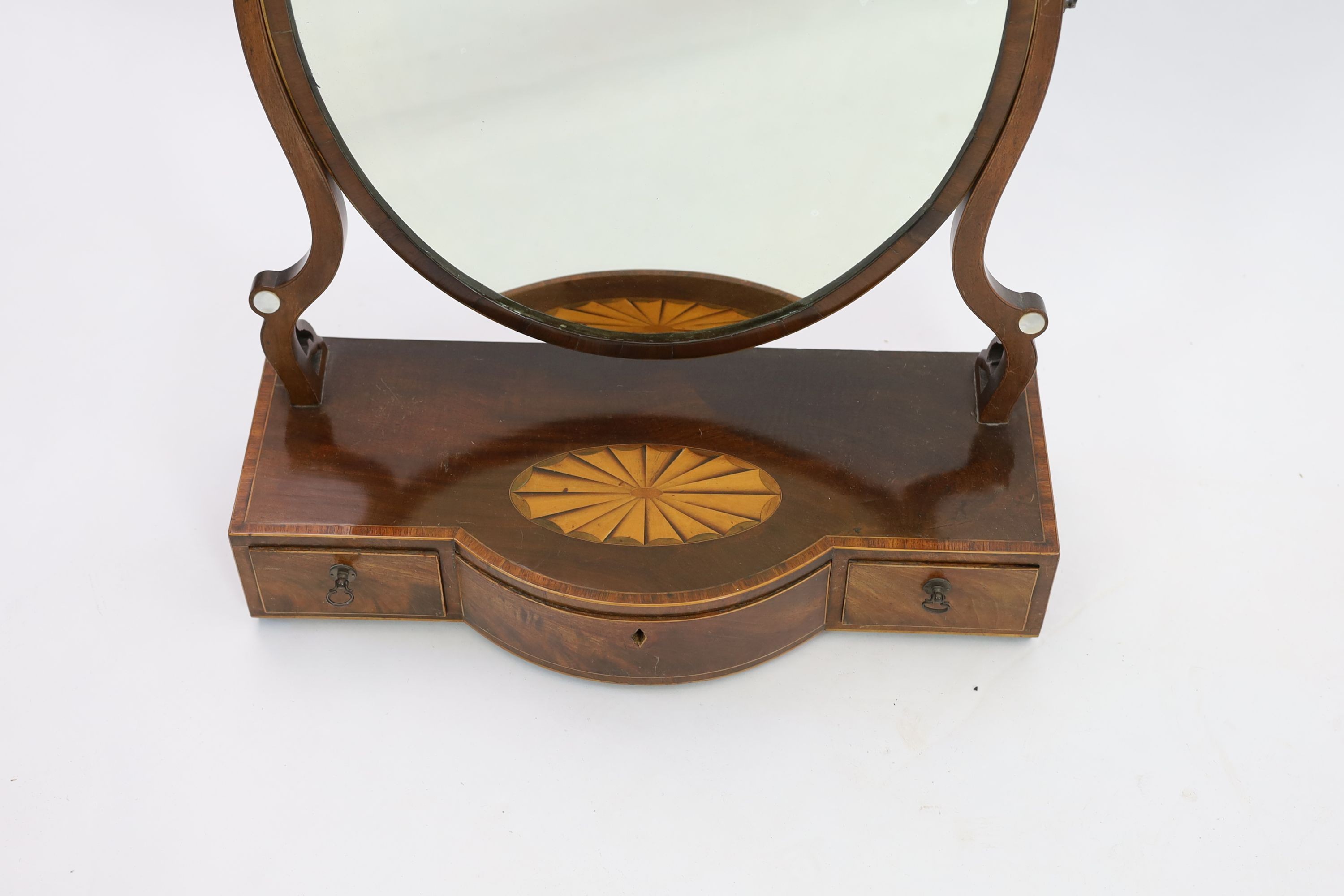 A George III mahogany satinwood paterae inlaid bowfront toilet mirror, width 57cm depth 24cm height 73cm